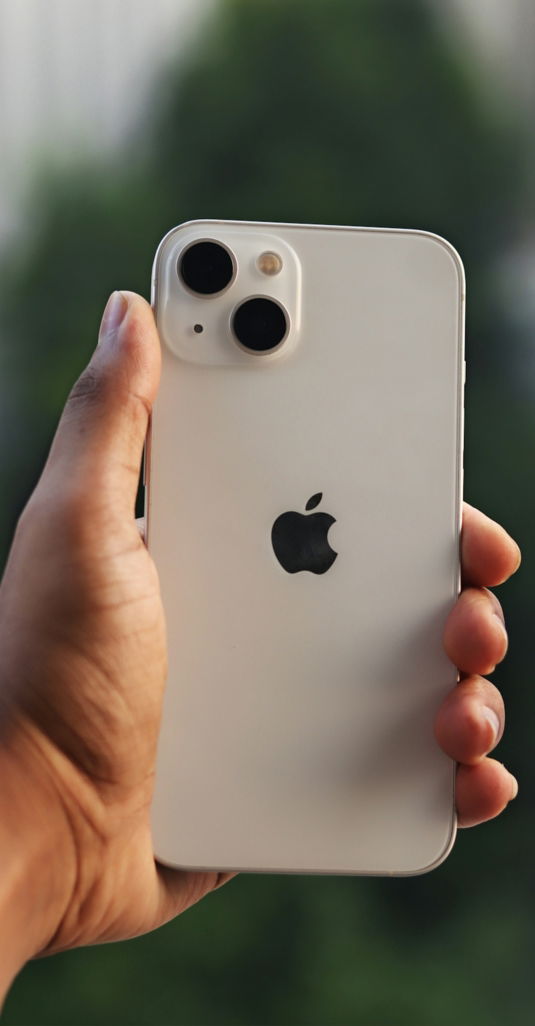 a hand holding a white cell phone